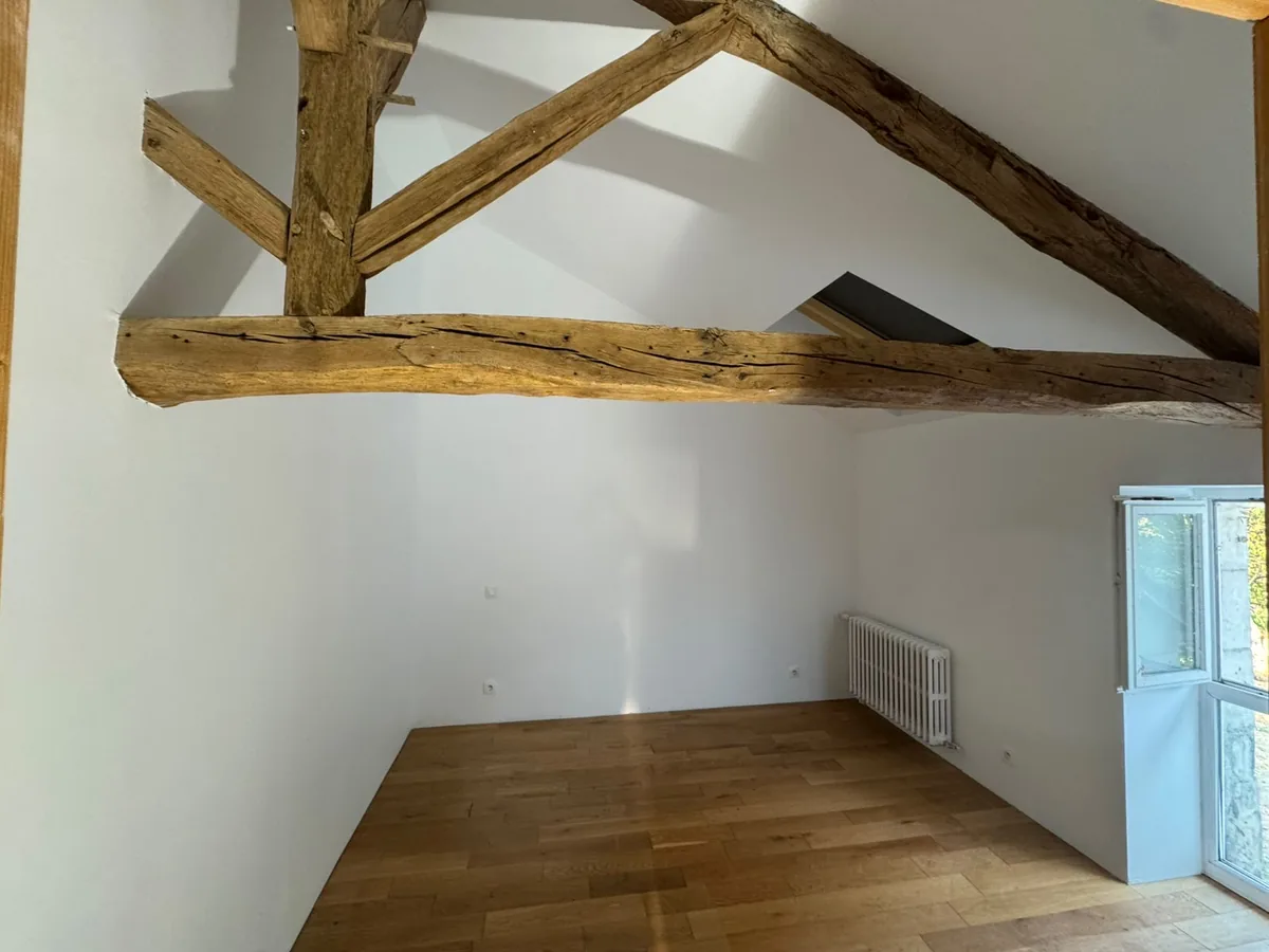 Combles aménagés à Chauvigny, plafond peint en blanc entre les poutres apparentes