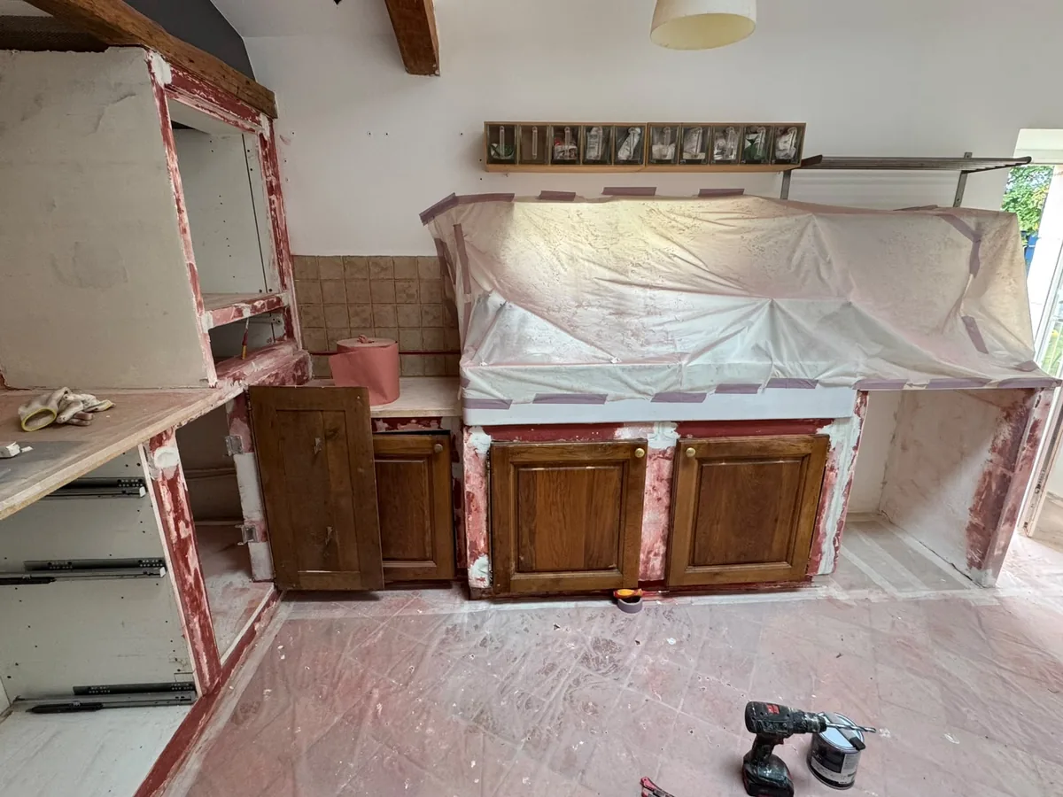 Cuisine en béton cellulaire mise en protection avant travaux : meubles bâchés, plan de travail masqué et sol protégé