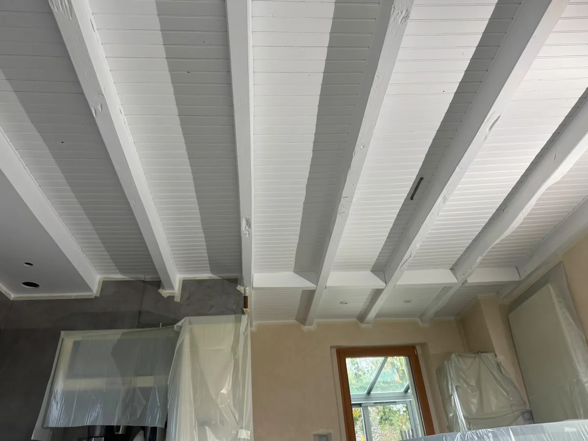Plafond à la française avec poutres et lambris repeints en blanc, chantier dans le 86