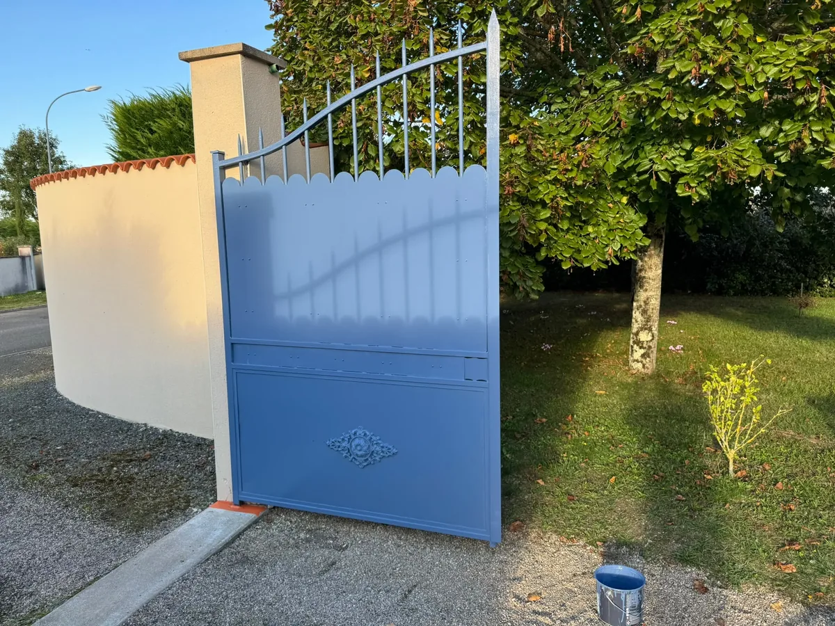 Portail métallique repeint en bleu et mur de clôture blanc à Chauvigny
